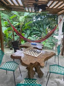 a chess board on a wooden table with chairs at Hostal y Camping Villa Guadua Tayrona in Santa Marta