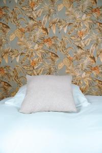 a pillow sitting on top of a bed with a wallpaper at Het Smaakhuis in Dwingeloo