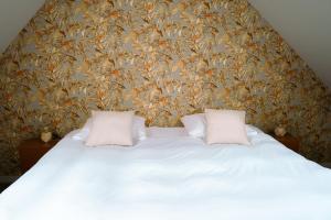 a bed with two pillows in a bedroom with a wallpaper at Het Smaakhuis in Dwingeloo