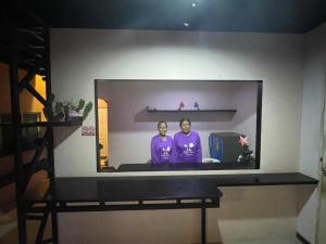 two people in a tv screen on a wall at หอพักสุพลเพลส Supol Place in Ban Bo