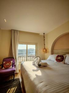 Kush Hotel, Grand Museum & Pyramids View في القاهرة: غرفة نوم بها سرير وكرسي ونافذة +37 صورة