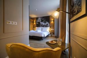 a hotel room with a bed and a table and a chair at Azores Book Hotel in Angra do Heroísmo