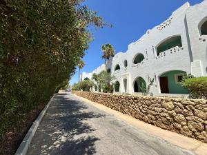 Sultan Sunscape - Premium Sea View Apartment at Domina Coral Bay في شرم الشيخ: شارع امام مبنى ابيض