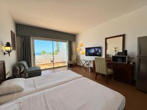 Sultan Sunscape - Premium Sea View Apartment at Domina Coral Bay في شرم الشيخ: غرفة فندق بها سرير ونافذة كبيرة