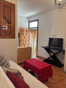 a living room with a couch and a table with a television at Casita Paloma in Pampaneira