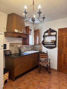 a kitchen with wooden cabinets and a chandelier at Casita Paloma in Pampaneira