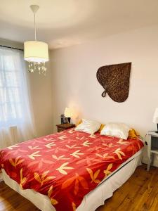 a bedroom with a bed with a red blanket at Le pont Saint Roch Logement lumineux avec garage in Lavaur