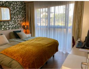 a bedroom with a bed and a large window at Reza Almere in Almere +30 photos