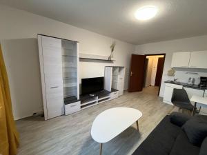 a living room with a white table and a kitchen at Moderne Studio-Apartments in Wolfen in Steinfurth +53 photos