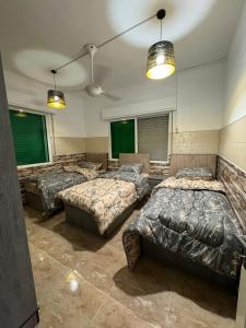 a room with three beds and two windows at Decapolis 8 in Irbid