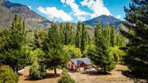 una casa en medio de un bosque de árboles en Chacra CheSuiza, en Epuyén
