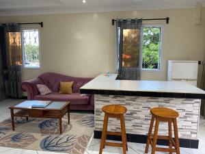 a kitchen and living room with a purple couch at Lalao in Toamasina