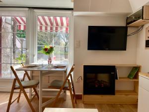 a living room with a table and a fireplace at Studio COZY avec jardin au centre ville d'Hendaye à 10 minutes d'Espagne in Hendaye