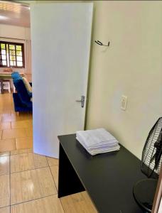 a room with a black table and a white door at Acomodação no centro de Tangará in Tangará