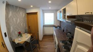 a small kitchen with a table and a stove at Ferienwohnung Landliebe in Oberwittstadt