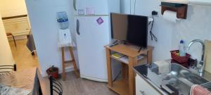 a kitchen with a refrigerator and a flat screen tv at Freedom GALLE in Río Gallegos