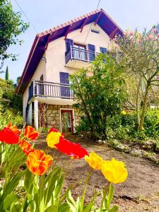 a house with red and yellow flowers in front of it at Les Balcons de Chambéry in Chambéry