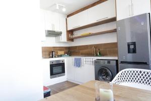 a kitchen with white cabinets and a wooden table at senator park in Cape Town