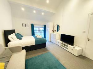 Un dormitorio con una cama y un televisor de pantalla plana. en Stylish Cosy 2 Bed Ilford Home with Free Parking, en Ilford