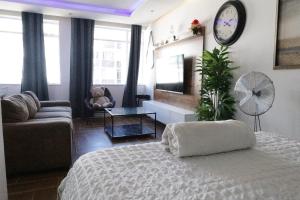 a bedroom with a bed and a couch and a clock at senator park in Cape Town