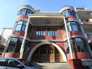 a red brick building with a car parked in front at Super Hotel O Tulip Inn in Gorakhpur