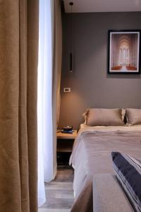 une chambre avec un lit et une table avec un tableau au mur dans l'établissement Vinhomes Greenbay Me Tri - Luxury, Garden Apartment in Hanoi, à Hanoï