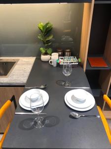 une table avec des assiettes et des verres à vin dessus dans l'établissement Vinhomes Greenbay Me Tri - Luxury, Garden Apartment in Hanoi, à Hanoï