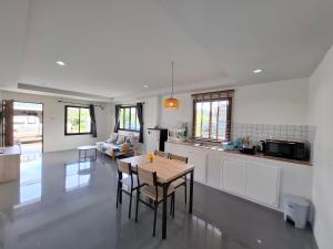 a kitchen and living room with a table and chairs at Lanta Cozy House 1 in Phra Ae beach