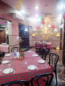 UnnāoHotel VISHAL PALACE的一间带桌椅和红色桌布的用餐室