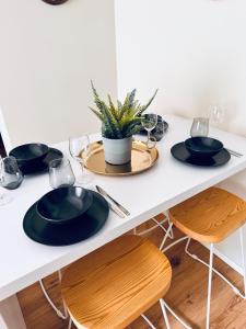 a table with black plates and glasses and a plant at Stelle di Verona - Rigel in Verona
