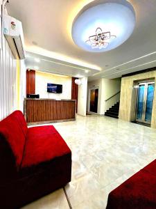 a living room with a red couch and a tv at Hotel Royal Central Haridwar in Haridwār