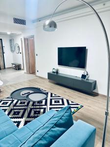 Una sala de estar con un sofá azul y un televisor de pantalla plana. en Regina's Sky View Apartment 32nd floor, en Skopje