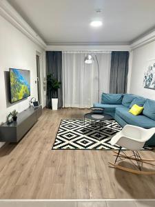 Una sala de estar con un sofá azul y una alfombra. en Regina's Sky View Apartment 32nd floor, en Skopje 48 fotos más