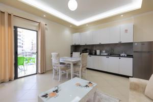 a kitchen and living room with a table and chairs at Vila Emi Apartment's in Durrës