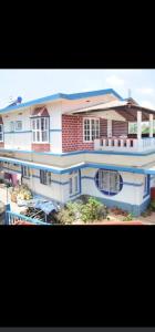 a large white house with blue trim at Balkis homestay in Madikeri