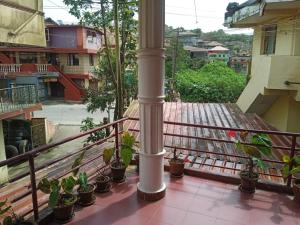 a balcony of a building with potted plants at Balkis homestay in Madikeri