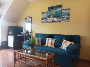 a living room with a blue couch and a table at Fotiadis - Cosy apartments and spectacular rooms in Veliko Tŭrnovo