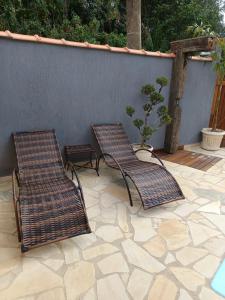 two wicker chairs and a table on a patio at Meu canto em Lumiar in Nova Friburgo