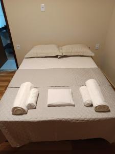 a bed with white sheets and towels on it at Meu canto em Lumiar in Nova Friburgo +85 photos