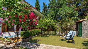ポルト・デ・ソリェルにあるApartment Bougainvilleaの2脚の青い椅子と花のある庭