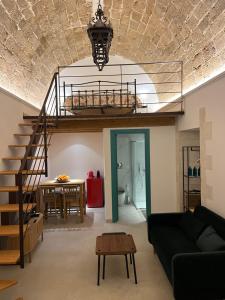 a living room with a couch and a spiral staircase at Arcate Barocche - Urban Lofts - Scicli in Scicli