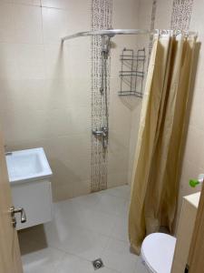 a bathroom with a shower with a toilet and a sink at Апартамент Дани in Obzor +33 photos