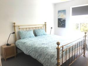 Un dormitorio con una cama grande con almohadas azules. en Golfandbeach, en Castlerock