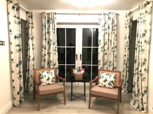 two chairs and a table in front of a window at Golfandbeach in Castlerock