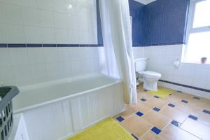 a bathroom with a bath tub and a toilet at Family house in Farnborough in Farnborough +21 photos