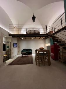 a living room with a staircase and a table at Arcate Barocche - Urban Lofts - Scicli in Scicli