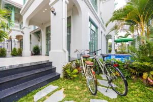 a bike parked on the grass in front of a house at JM Villas Tropical Khem Beach in Phu Quoc