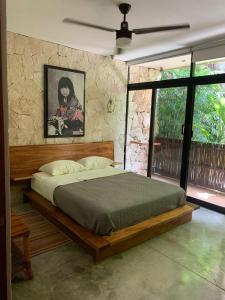 a bedroom with a bed and a painting on the wall at Bohemian Rainforest Chemuyil in Chemuyil