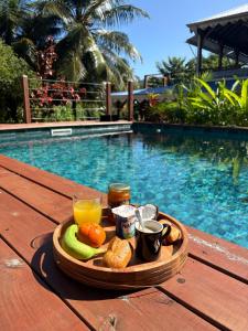a tray of food on a table next to a pool at Villa Mamalouken App Manea in Quartier Préfontaine