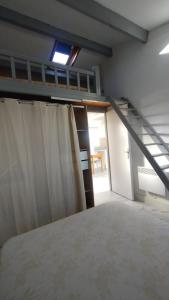a bedroom with a bunk bed and a staircase at Appartement T2 en résidence Naturiste en bord de Mer in Leucate-Plage